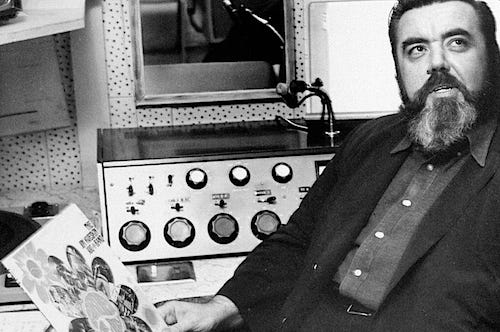 San Francisco radio legend Tom Donahue sits in front of a vintage 1960s radio mixing console holding a rock record album San Francisco radio legend Tom Donahue sits in front of a vintage 1960s radio mixing console holding a rock record album
