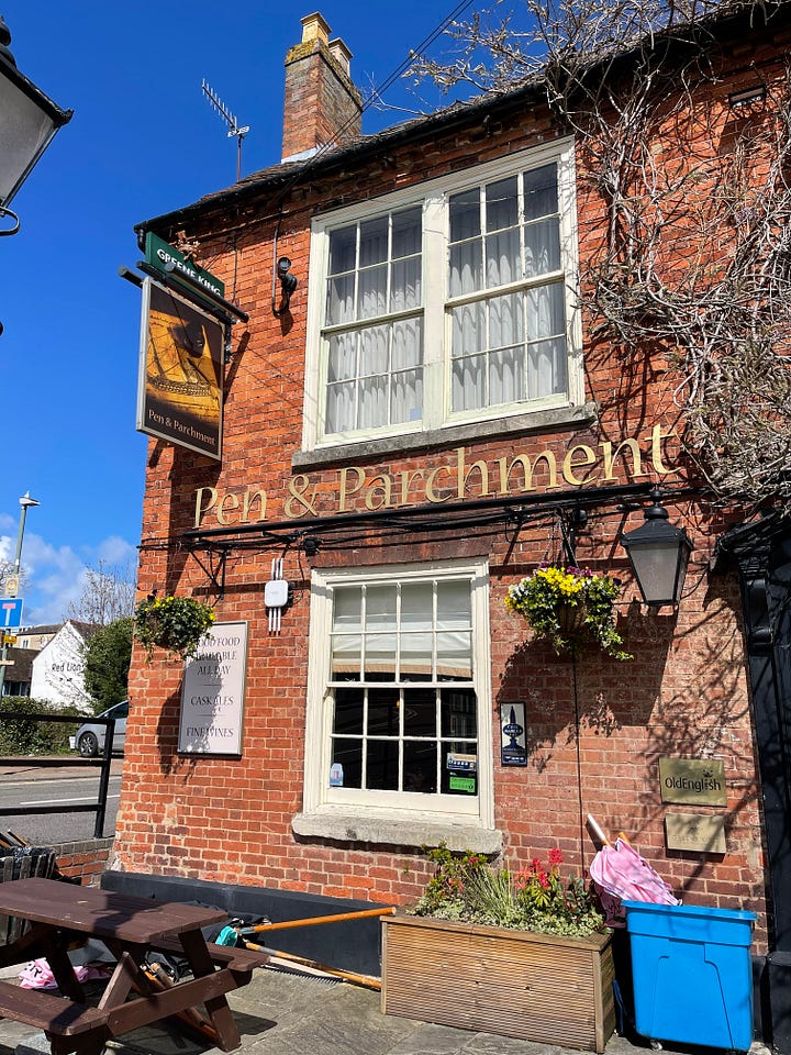 Old Tudor house with wood beams, old windows against a blue sky; swans and ducks on the River Avon; The old public librabry in white and wood Tudor style; The Royal Shakespeare Theatre; The Pen and Parchment pub with sign hanging, windows and flowers