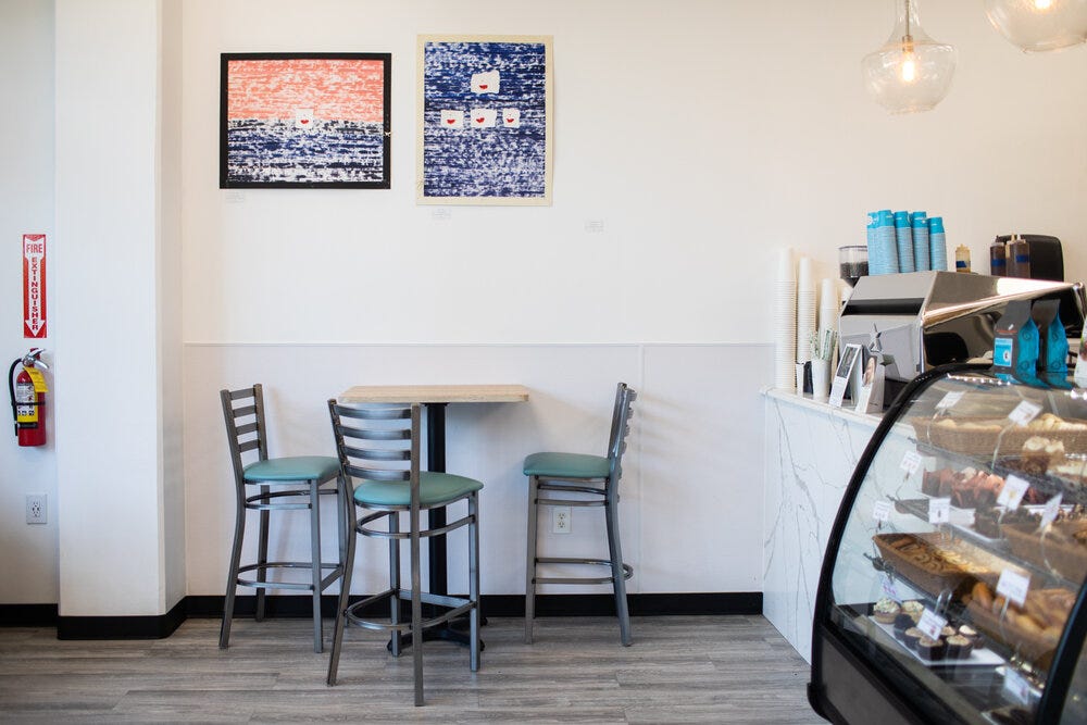 The coffee bar is seen on the far end of the interior. The coffee bar is seen on the far end of the interior.