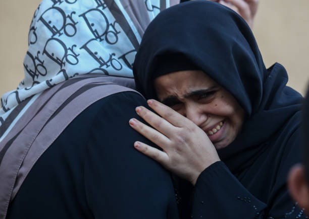 People mourn as they wait to collect the bodies of friends and relatives killed in an airstrike on December 26, 2023 in Khan Yunis, Gaza. More than...