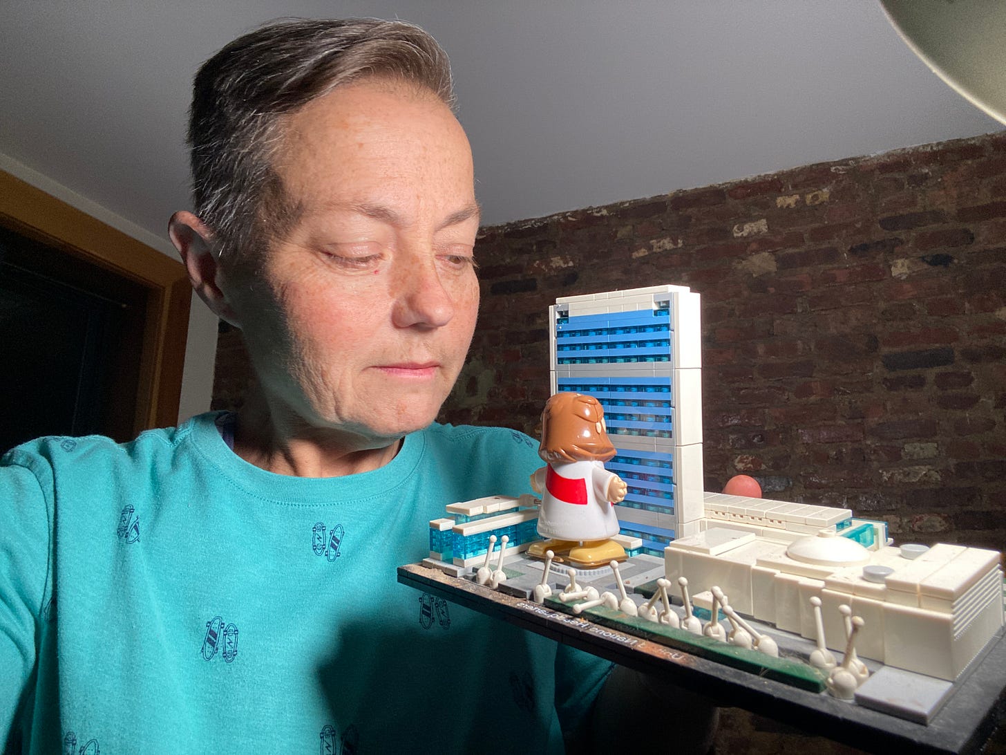 comedian kelli dunham holding Lego Jesus and 40 story building set