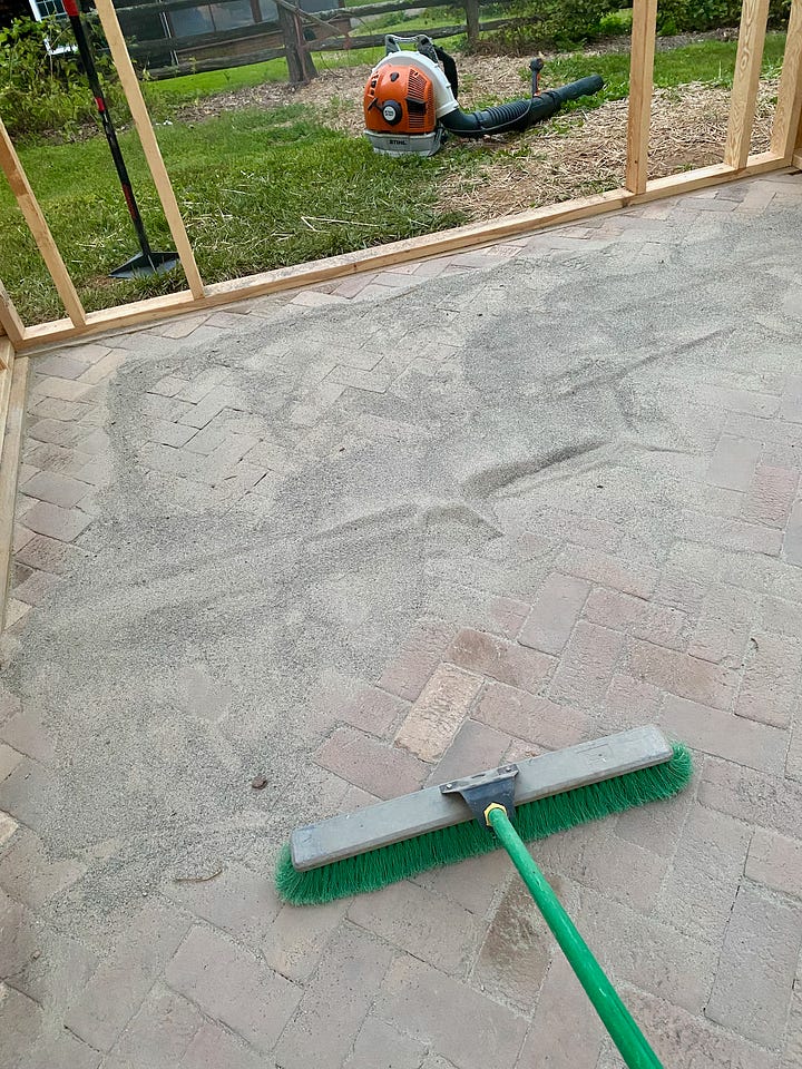 Mosaic of a brick paver floor being installed.