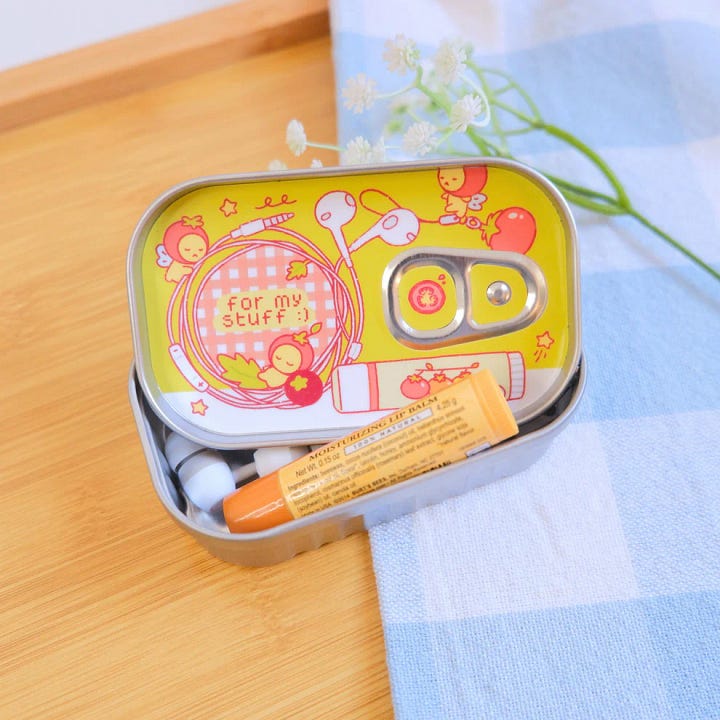 First photo: a fused glass photo and frame. Second photo: a metal tin with illustrated, anthropomorphic tomatoes.   