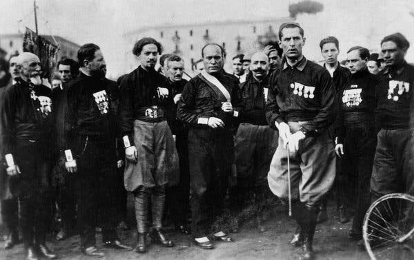 A black-and-white photograph of Mussolini and some Blackshirts.