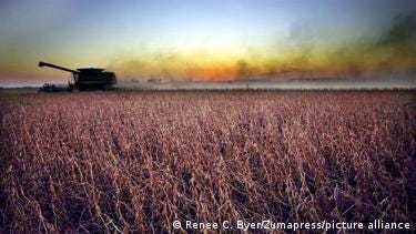 A combine harverster spreads chemicals on a field. A combine harverster spreads chemicals on a field.