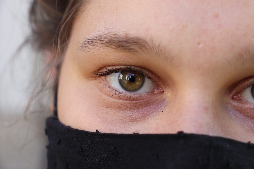 a woman covers her face, her eyes have seen too much
