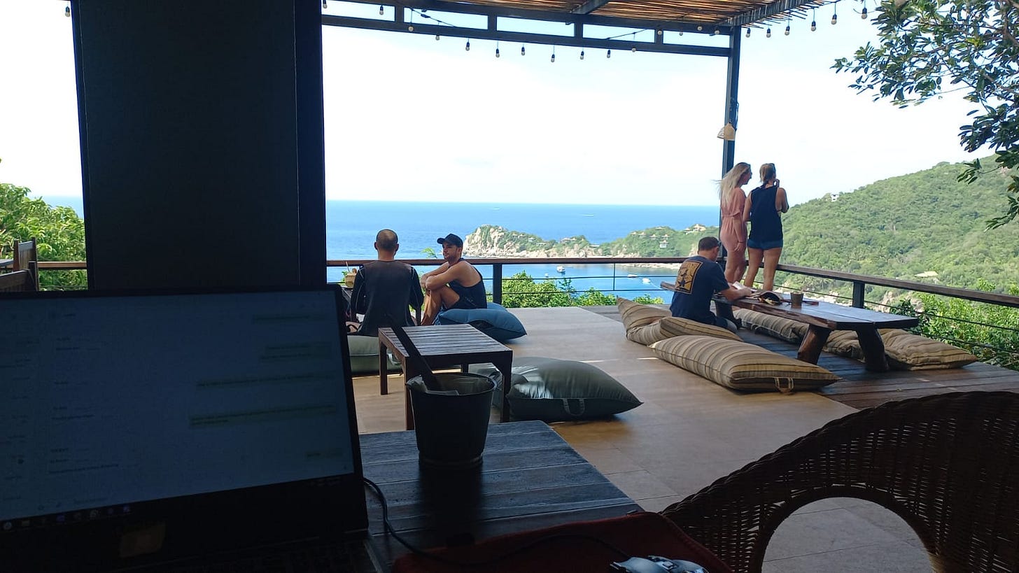 photo of a computer in a table at a reastaurant with an overview of the sea and nature