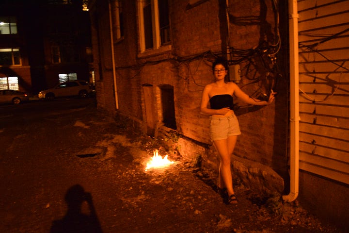 four photos of a young woman standing or crouching before burning poplar fluff in an alley