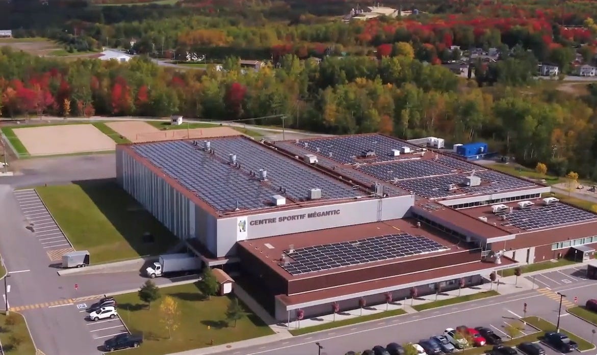 Aerial photo of municipal sports center with solar panels covering roof Aerial photo of municipal sports center with solar panels covering roof