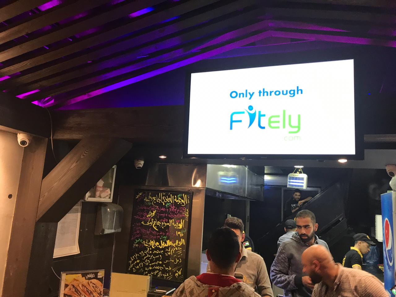 A digital screen with an ad from a startup called Fitely
