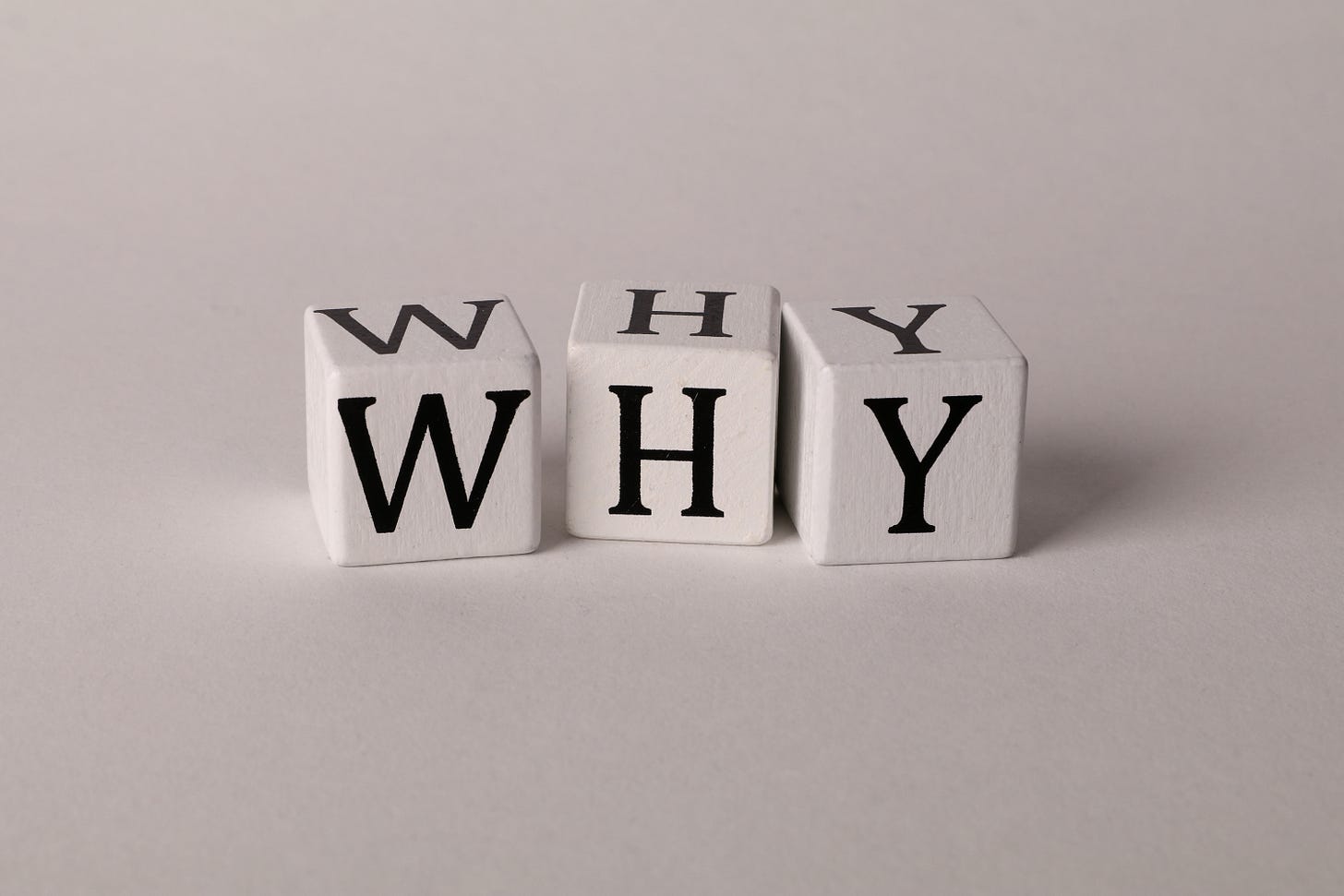 White blocks on a tan background with blocks that spell out why