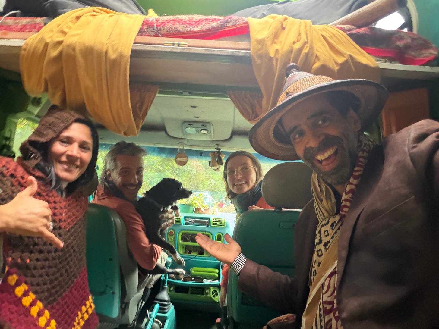 Four people and a dog inside a colorfully decorated caravan