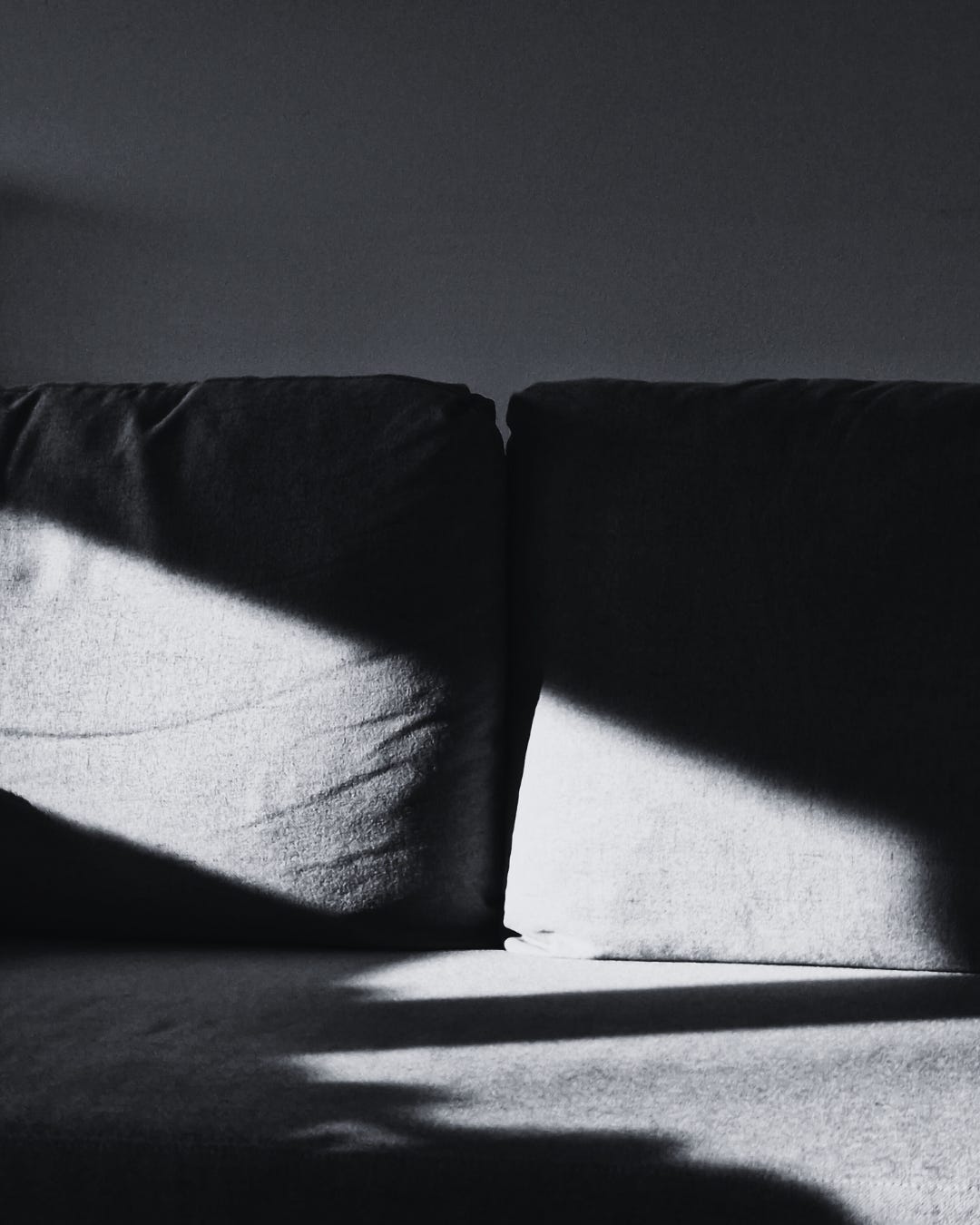 A couch with a ray of light falling across it.