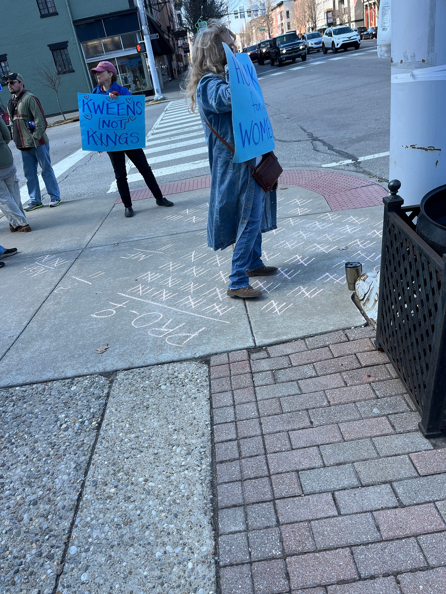 Another sidewalk, with a couple of protesters and chalk marks on the sidewalk, over 200 in the positive column, about fifteen in the negative category