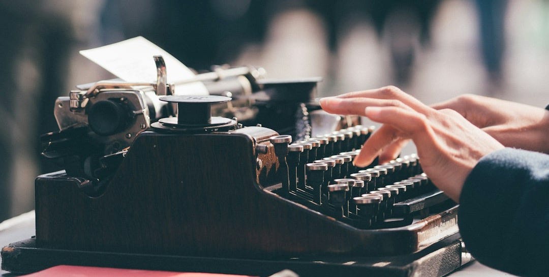 person using black typewriter