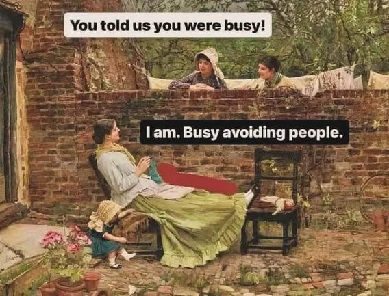 Classical painting shows a woman in a green skirt and white blouse seated on a chair knitting with legs extended, a small girl in a bonnet and dress standing beside her holding flowers, another child peeking over a brick wall with laundry in the background, potted plants nearby, and overlaid text You told us you were busy! at top and I am. Busy avoiding people. at bottom.