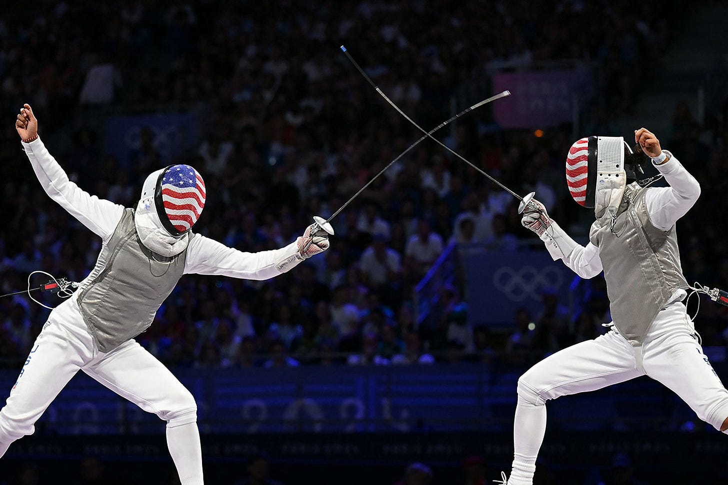 The fencers, both with USA flags printed on their masks, touch swords as they compete