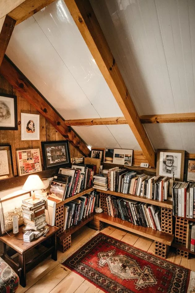 This may contain: an attic with bookshelves and pictures on the wall