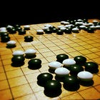 Go board with black and white stones mid-game.