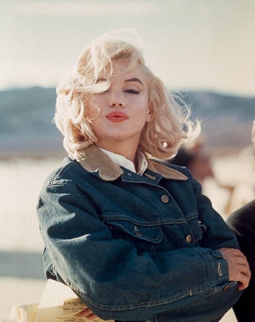 This may contain: a woman with blonde hair sitting on a bench