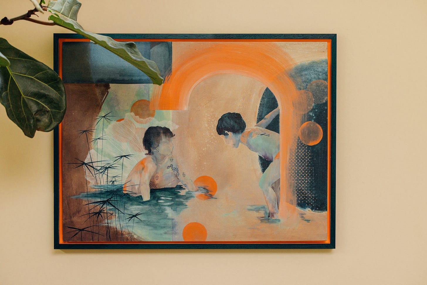 Assia Bennani's Playtime in a dark teal frame with an orange inner edge. Two children play in shallow water beneath a sweeping orange arch, with orange circles and reeds around them. Fiddle-leaf fig leaves cross the top left corner.