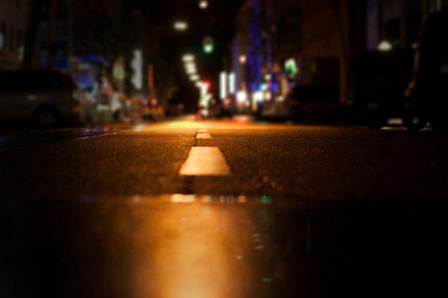 A low photograph of a city street. Only the road is in focus. 