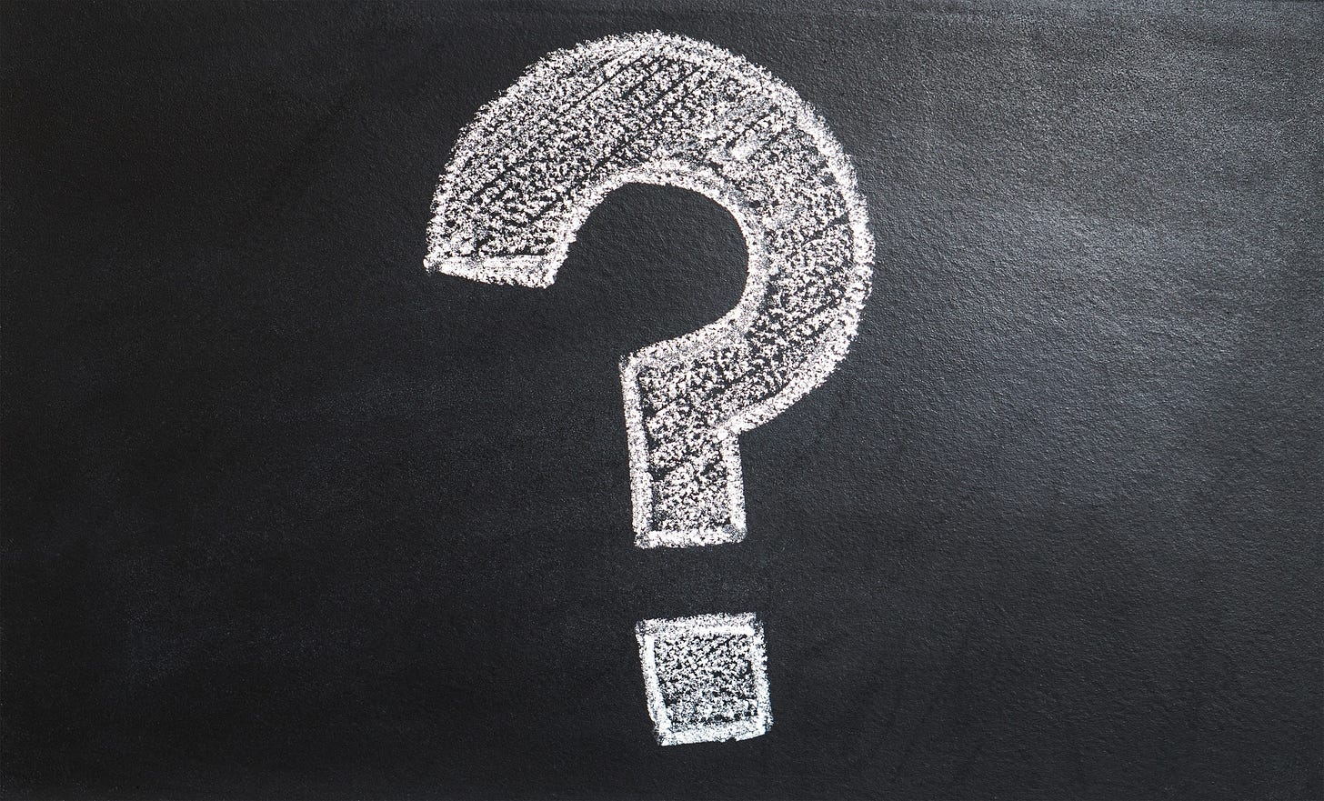 a blocky question mark drawn in white chalk on a black board