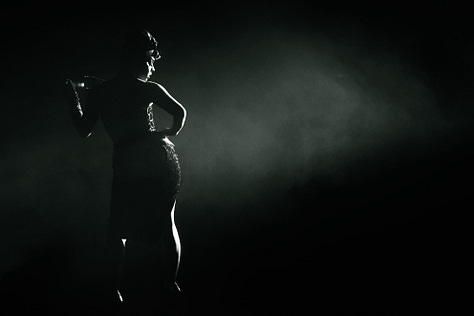 images of burlesque performers on stage with artistic lighting