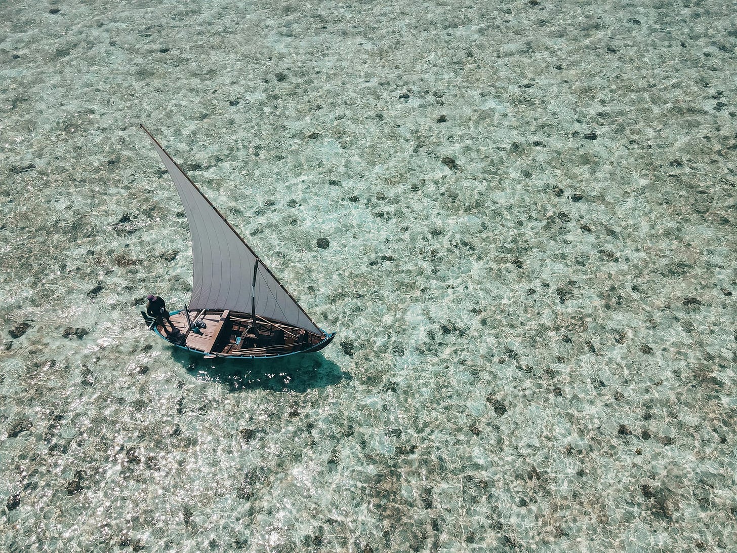 Aerial view of a sailboat in glistening water Aerial view of a sailboat in glistening water