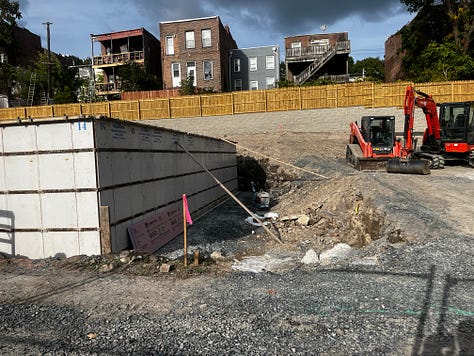 Photo of machinery on a construction site and new foundations being poured.