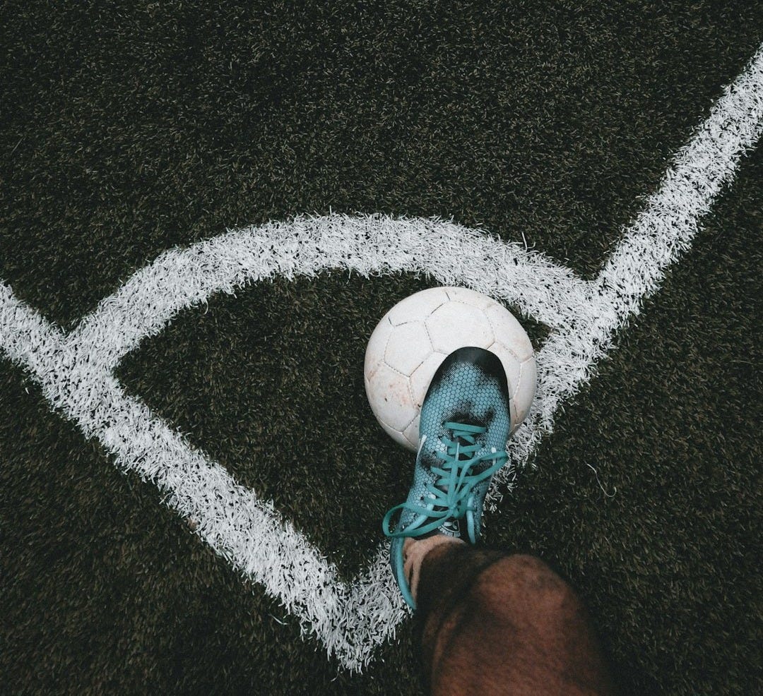 a person standing on a field with a soccer ball a person standing on a field with a soccer ball