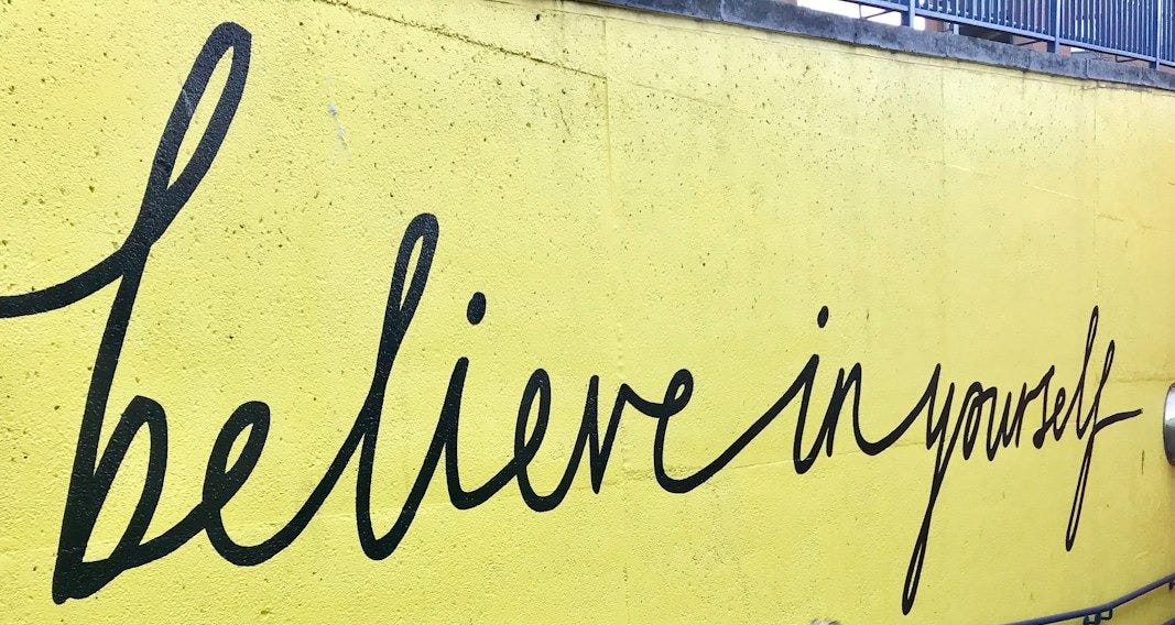 toddler looking at believe in yourself graffiti