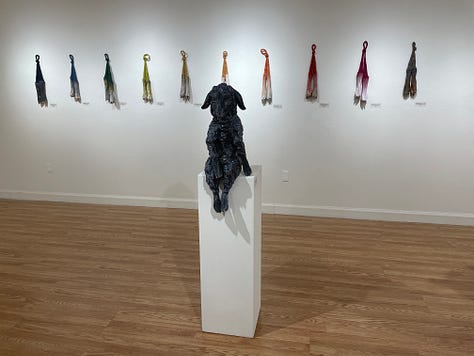 Installation views of a gallery with several artworks depicting sheep. All works are made of ceramic with fiber attachments connecting them together.