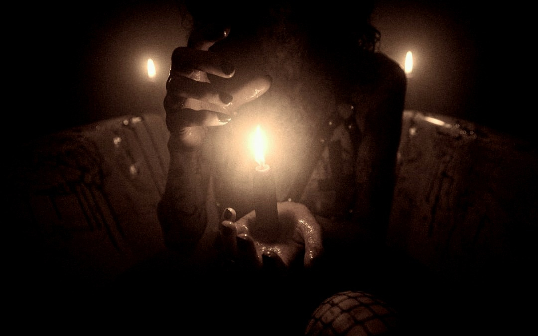 a person holding a lit candle in their hand