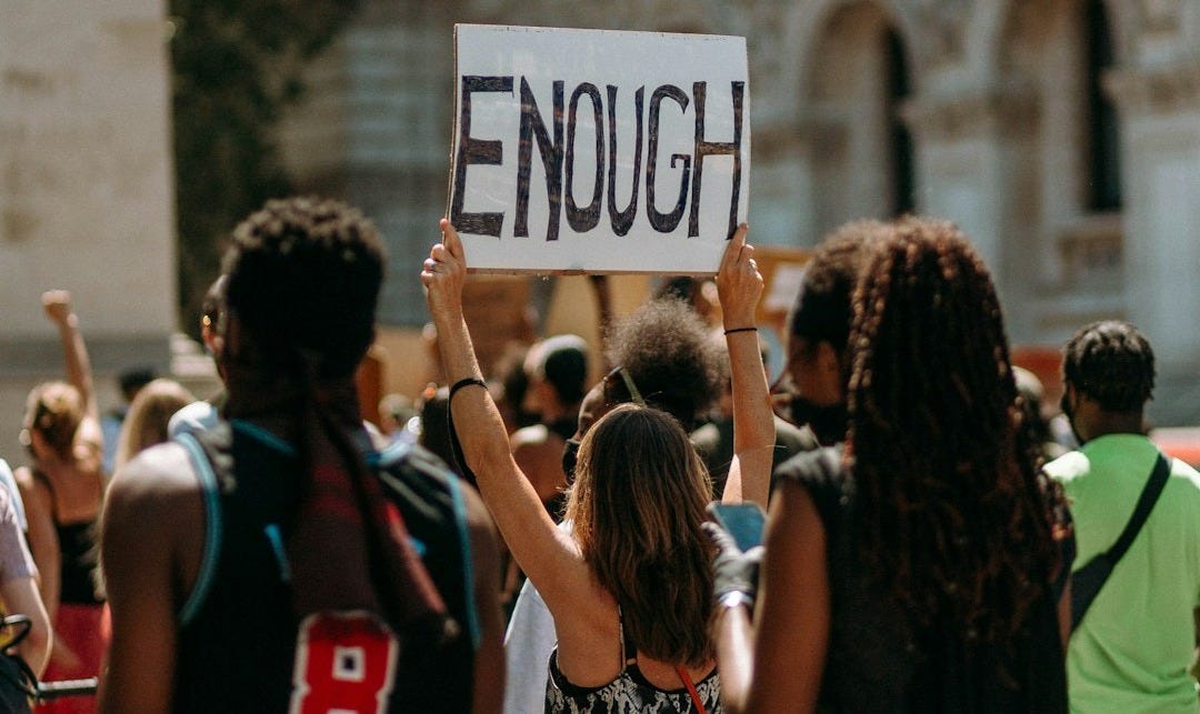 people holding a signage during daytime people holding a signage during daytime