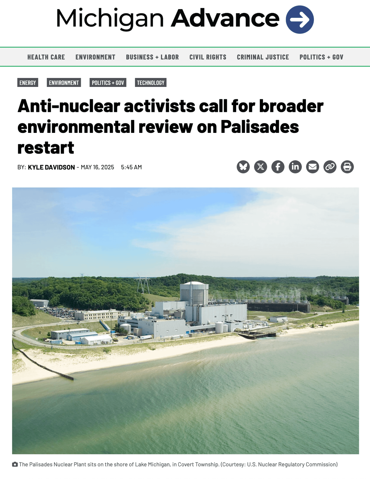 A photo of the Palisades nuclear plant on the shore of Lake Michigan in Covert Township. The facility includes multiple industrial buildings, cooling towers, and structures near a sandy beach with trees and water in the background. The image shows a clear, sunny day with a blue sky.