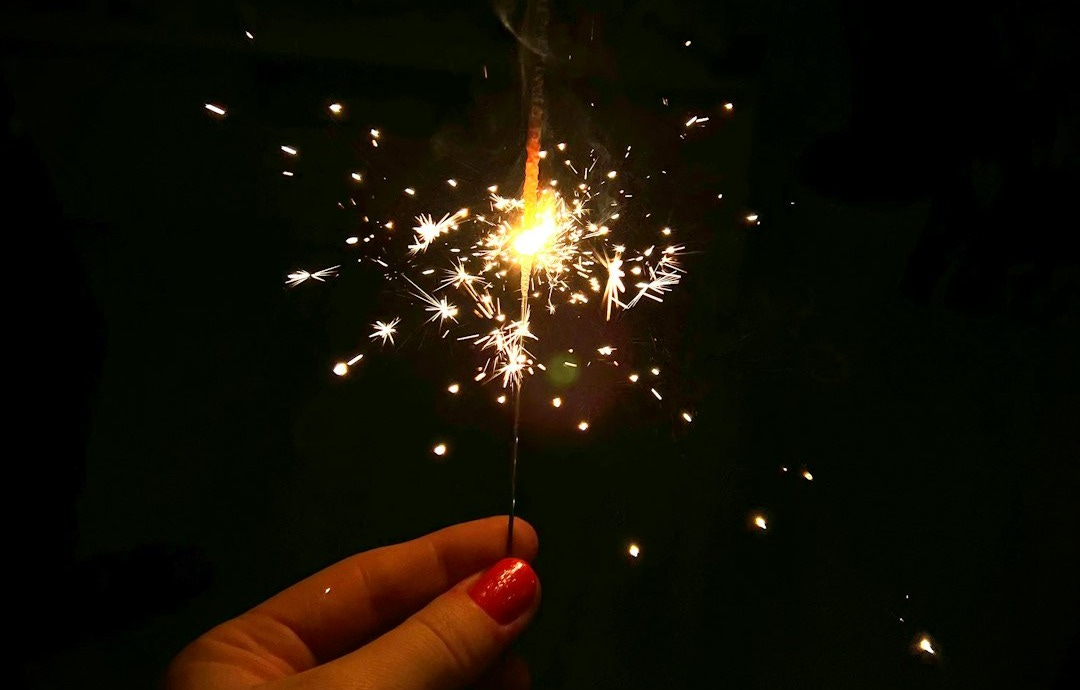 a hand holding a sparkler in the dark