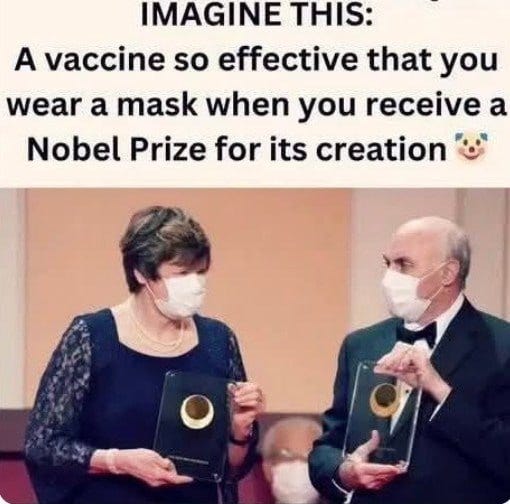 A woman with brown hair wearing a light-colored lace dress and pearl necklace holds a black circular award while wearing a white face mask. Beside her a bald man in a black tuxedo and bow tie holds a similar black circular award while also wearing a white face mask. They stand on a stage with a blurred audience in the background.