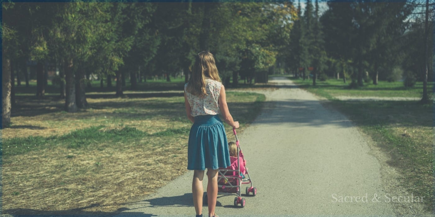 A child sitting in a buggy being pushed along a path in soft sunlight, evoking themes of childhood memory and reflection.