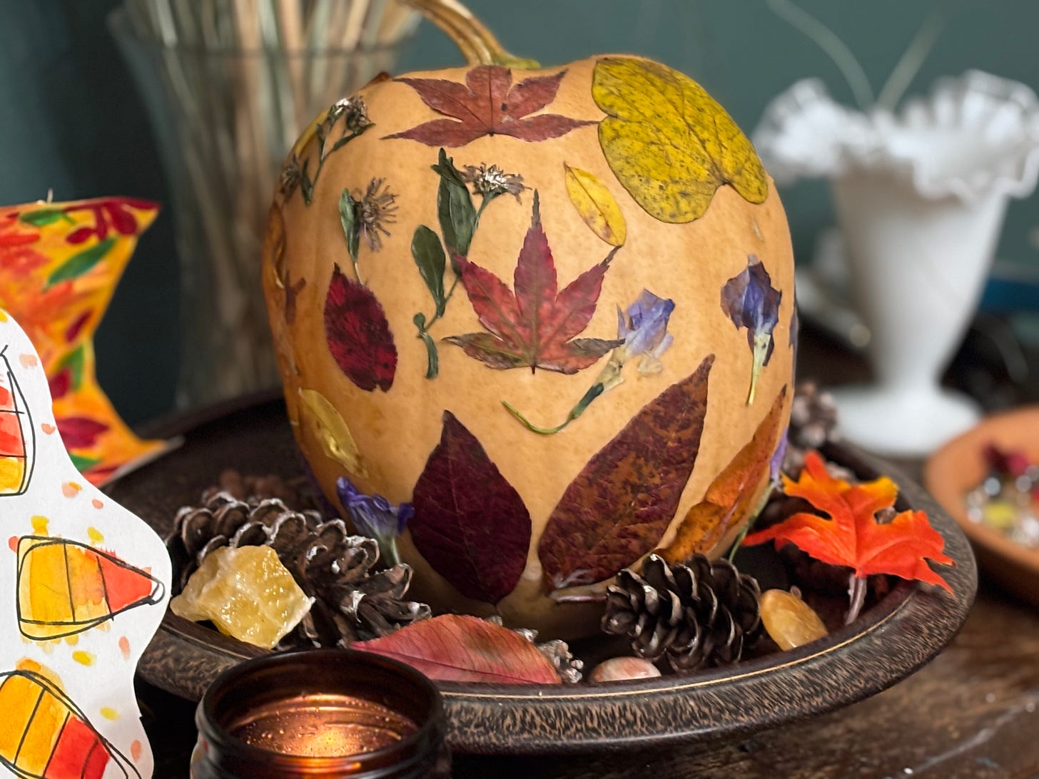 a pumpkin decorated with leaves and flowers