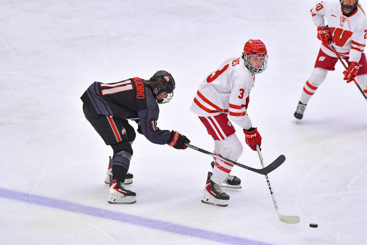 Mackenzie Jones (right) carries the puck near the blue line as kaia Malachino approaches from behind her trying to poke the puck away Mackenzie Jones (right) carries the puck near the blue line as kaia Malachino approaches from behind her trying to poke the puck away