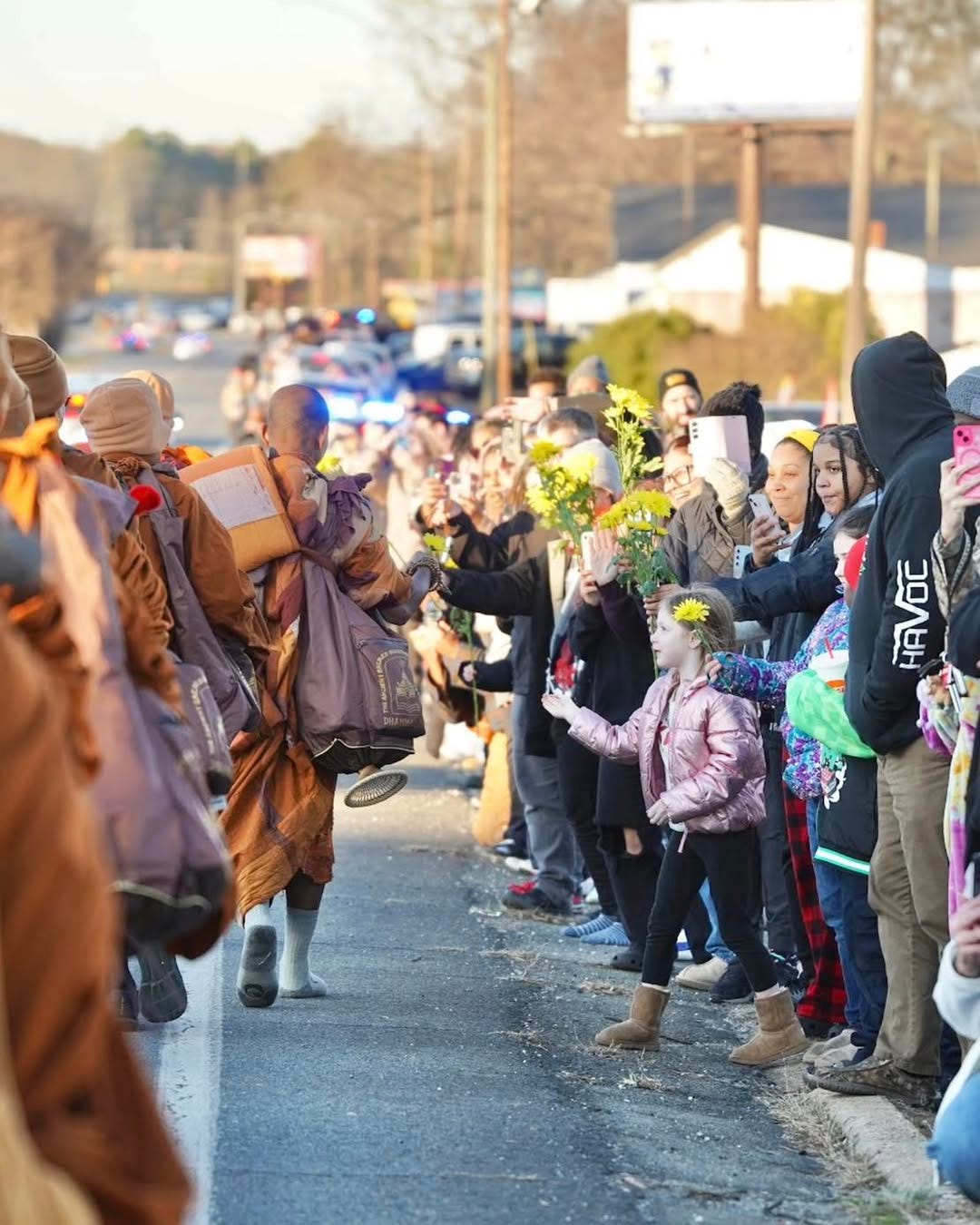 May be an image of one or more people, crowd, road and text
