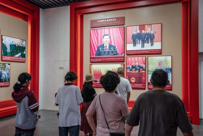 Visitors looking at photographs of Chinese President Xi Jinping at the site of the First National Congress of the Chinese Communist Party.