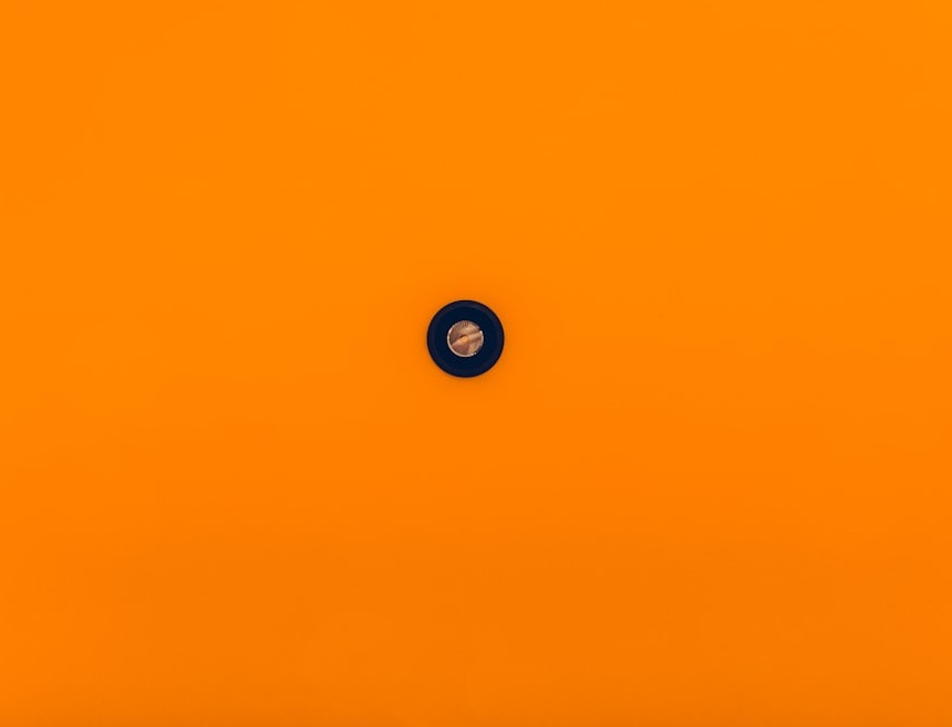 an orange background with a black circle in the center