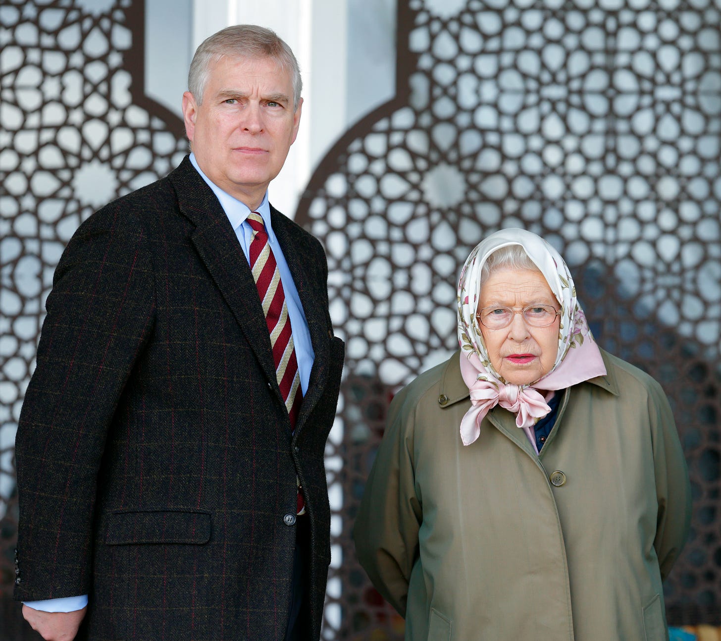 Andrew Mountbatten-Windsor wearing a suit frowning standing next to the Queen in a Khaki coat Andrew Mountbatten-Windsor wearing a suit frowning standing next to the Queen in a Khaki coat