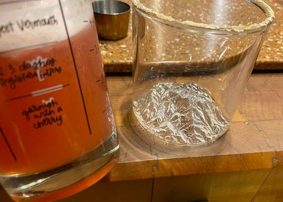 cocktail shaker next to a glass tumbler