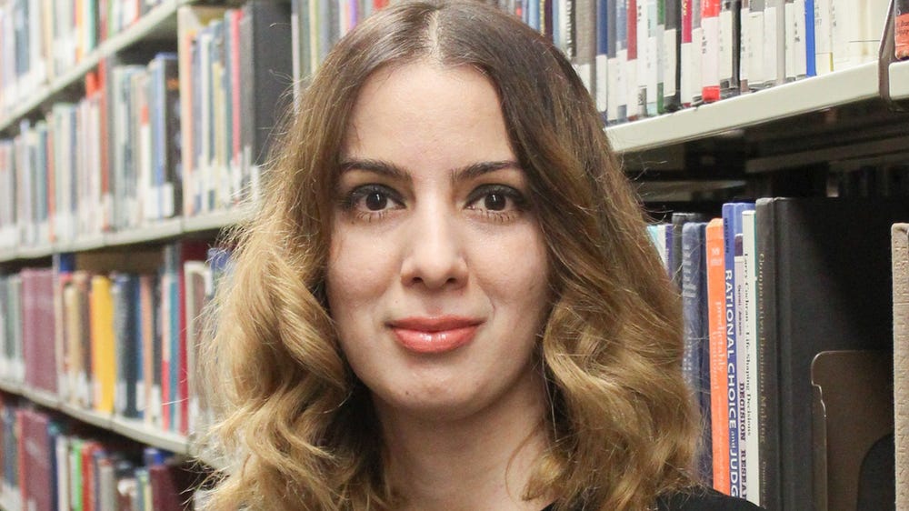 Portrait of Dr. Shermeen Yousif in a library Portrait of Dr. Shermeen Yousif in a library