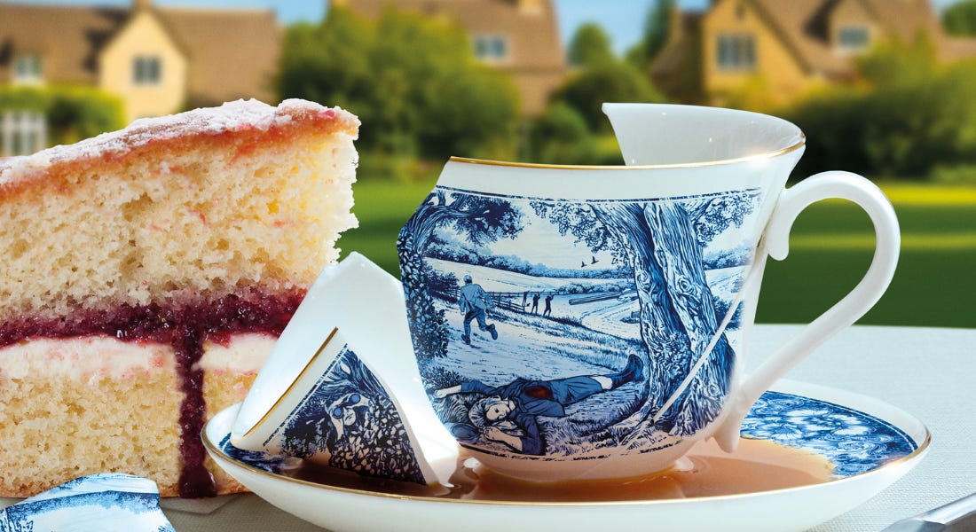 A broken blue and white tea cup with a slice of cake next to it and houses behind it A broken blue and white tea cup with a slice of cake next to it and houses behind it