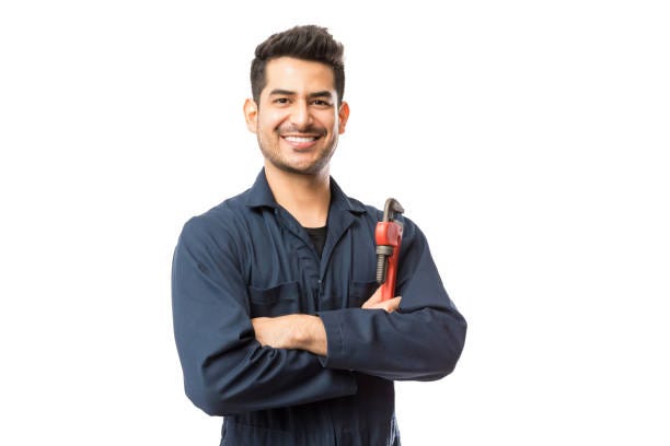Smiling Male Plumber With Pipe Wrench Standing Arms Crossed Portrait of smiling young male plumber with pipe wrench standing arms crossed on white background plumbing stock pictures, royalty-free photos & images