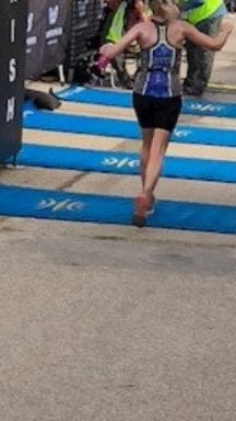 Runner seen from the back crossing the finish line of the Wildflower triathlon, similar to the finish line of a manuscript Runner seen from the back crossing the finish line of the Wildflower triathlon, similar to the finish line of a manuscript